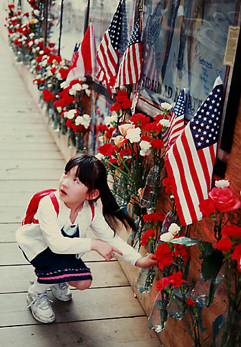 Girl places flowers on Memorial